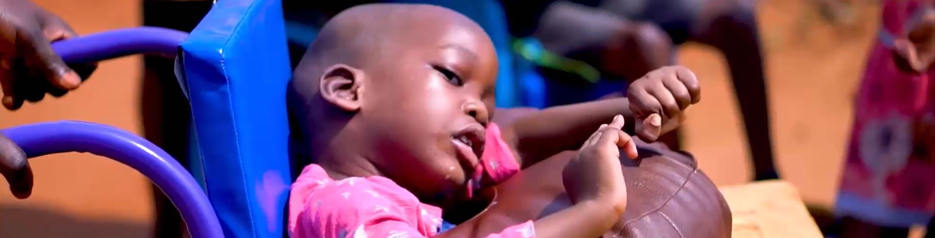 Little girl in pink dress in wheelchair